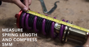 Measuring the length of an uncompressed coil spring on an aftermarket coilover strut. 